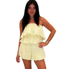 Woman wearing a light yellow strapless set on a white background