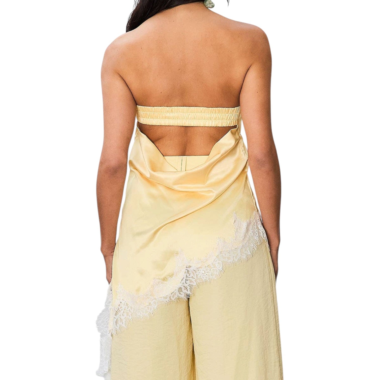 Woman wearing a yellow strapless dress with lace details on a white background