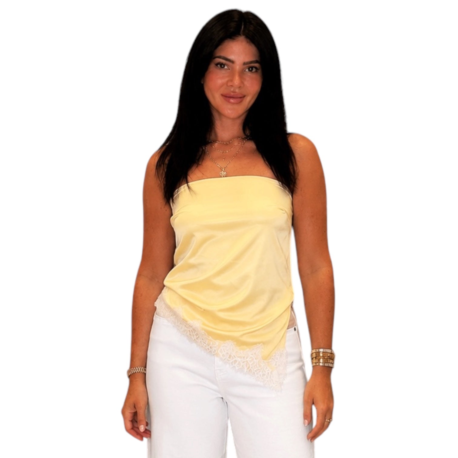 Woman wearing a yellow strapless top and white pants on a white background