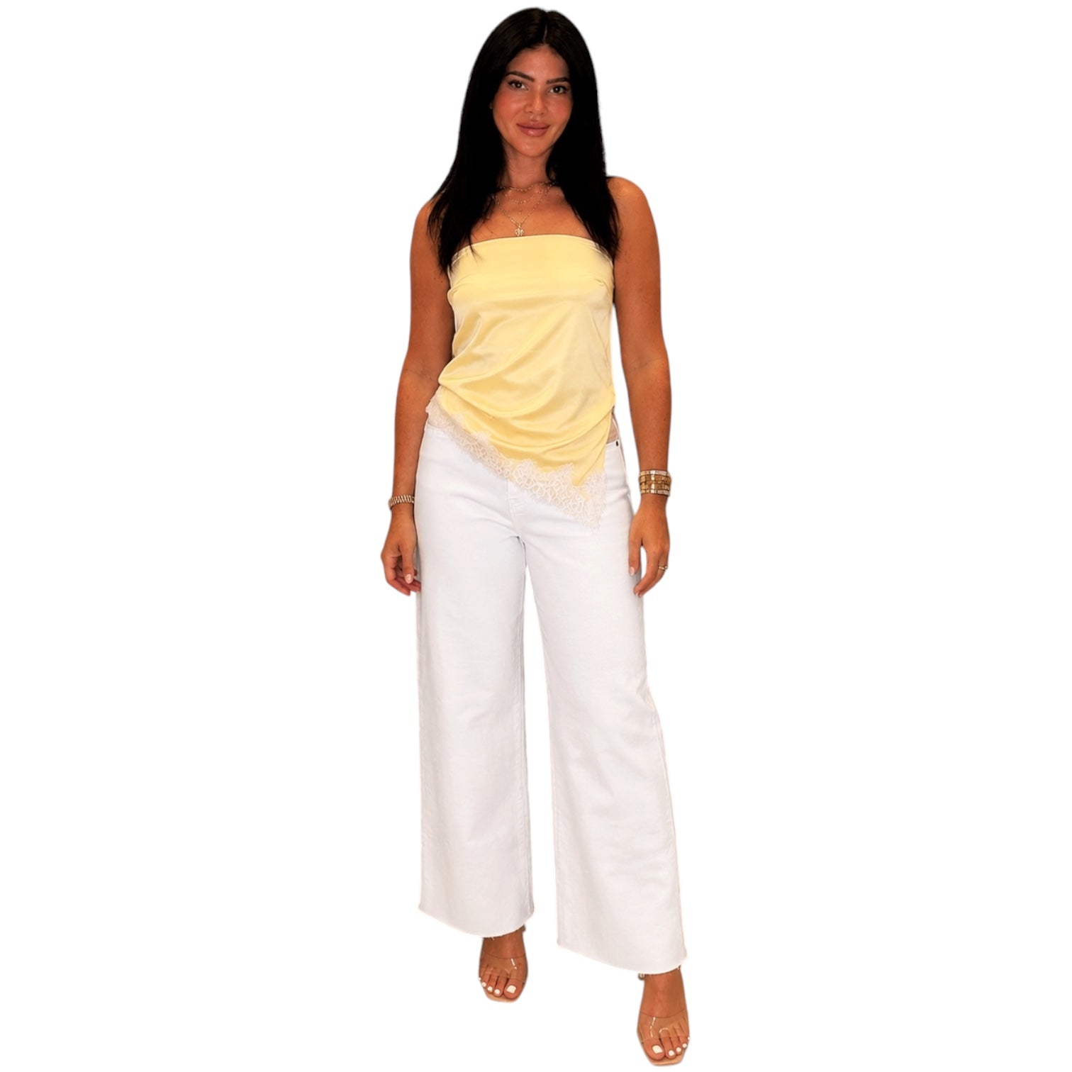 Woman wearing a yellow top and white pants on a white background