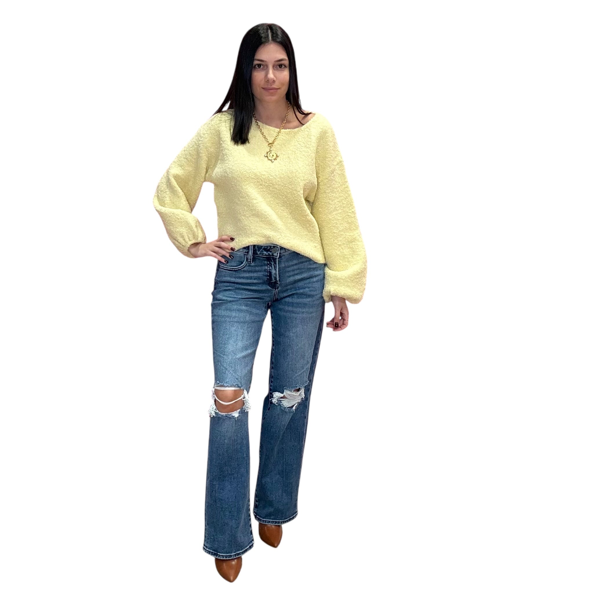 Woman wearing a yellow sweater and blue jeans on a white background