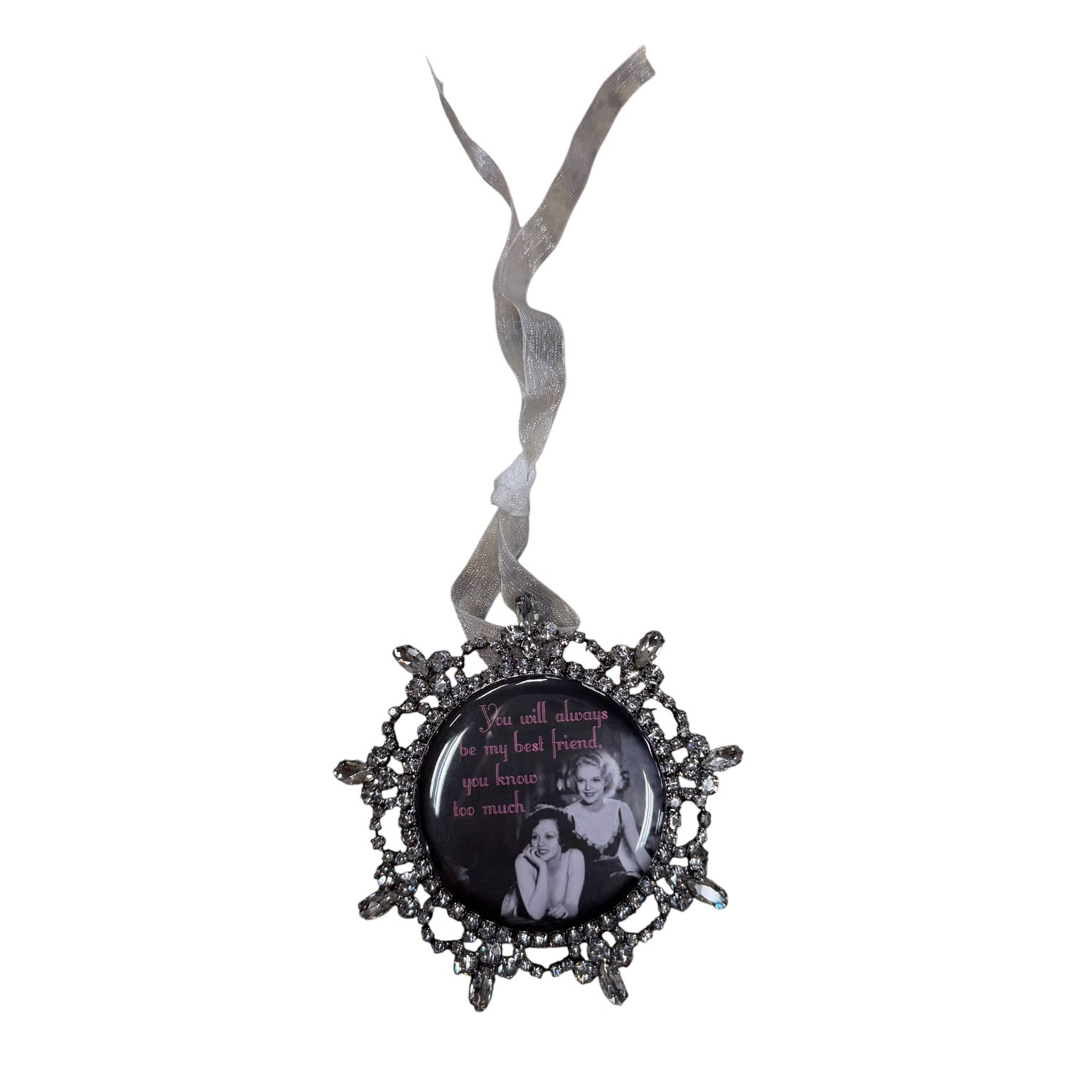 A gothic-style hanging ornament with an ornate dark metal frame and a ribbon loop, featuring a circular insert with a black background, a black-and-white photo of two women, and pink text.