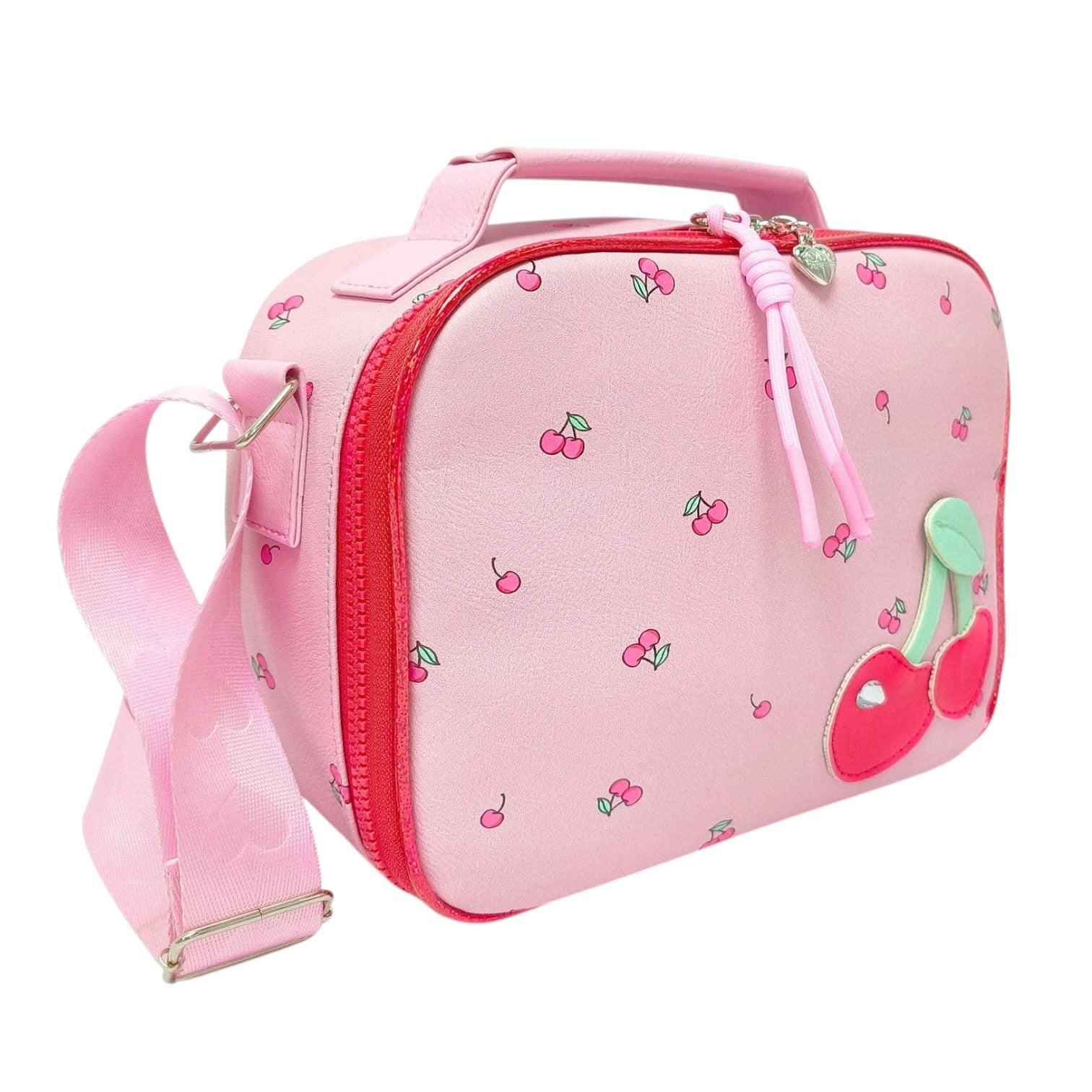 A pink soft-sided lunch bag with a cherry print, featuring a top handle, zippered closure, matching pink shoulder strap, and a large 3D cherry applique on the front.