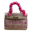 Handbag with pink bandana handle and text on a white background