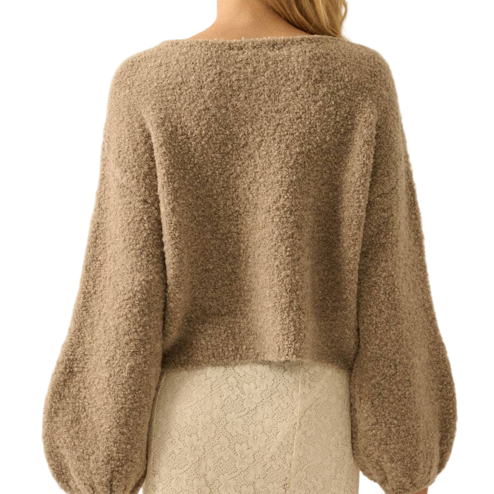 Woman wearing a brown fuzzy sweater against a beige background