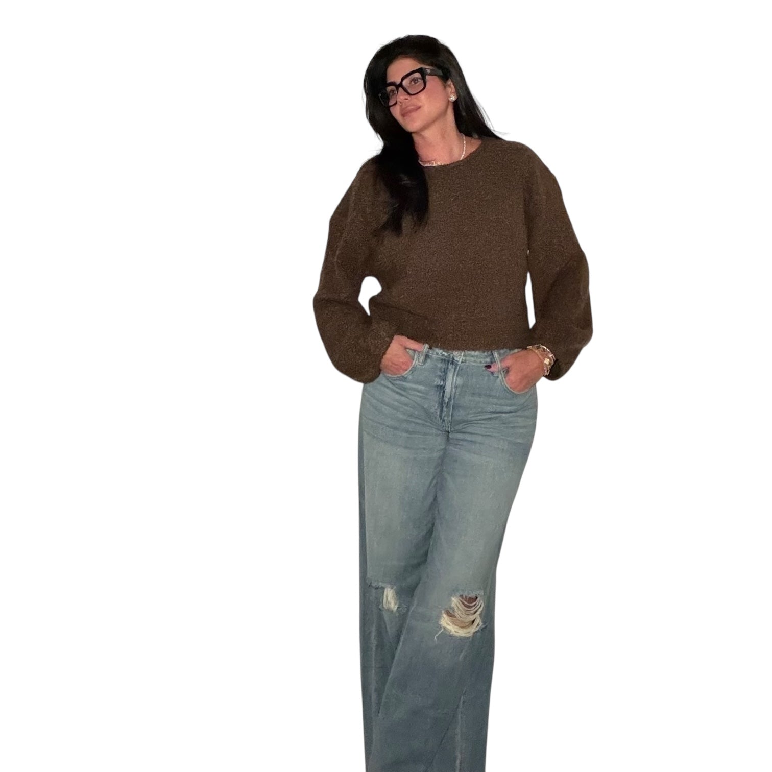 Woman wearing a brown sweater and light blue jeans on a white background