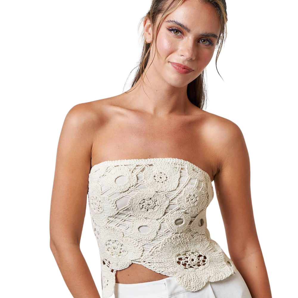 Model wearing a Crochet Flyaway Tube Top with intricate detailing, styled with loose white pants.