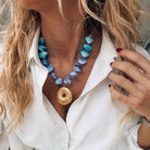Gold large urchin statement necklace with blue scallop shells, perfect for summer beach outfits.