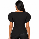 A woman shown from the back wearing a black short-sleeve top with dramatic puff sleeves and a structured waist, paired with black pants against a plain white background.